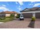 Charming home with a paver driveway, two-car garage, manicured lawn, and tropical landscaping at 4721 Tortona Ct, Bradenton, FL 34211