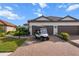 Charming home with a paver driveway, two-car garage, manicured lawn, and tropical landscaping at 4721 Tortona Ct, Bradenton, FL 34211