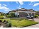 Charming home with a paver driveway, two-car garage, manicured lawn, and tropical landscaping at 4721 Tortona Ct, Bradenton, FL 34211