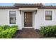 Charming home entrance with a welcoming brown door, brick walkway, manicured shrubbery, and neutral paint at 4721 Tortona Ct, Bradenton, FL 34211