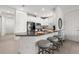 Beautiful kitchen featuring white cabinets, a granite counter bar, modern stools, and stainless steel appliances at 4721 Tortona Ct, Bradenton, FL 34211