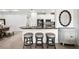 Modern kitchen bar area with white cabinetry, granite countertops, stylish stools, and stainless steel appliances at 4721 Tortona Ct, Bradenton, FL 34211