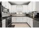 Modern kitchen featuring white cabinets, stainless steel appliances, mosaic backsplash, and granite countertops at 4721 Tortona Ct, Bradenton, FL 34211