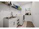 Well-lit laundry room with sink, cabinetry and a modern washer and dryer at 4721 Tortona Ct, Bradenton, FL 34211