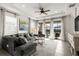Inviting living room with a plush gray sofa, tray ceiling, bright natural light, and patio access at 4721 Tortona Ct, Bradenton, FL 34211