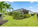 Landscaped backyard featuring palm trees, tropical plants, and manicured lawn at 4813 Sparkling Sea Ln, Lakewood Ranch, FL 34211