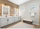 Bright bathroom featuring double sink vanity, wood accent wall, modern lighting and a decorative rug at 4813 Sparkling Sea Ln, Lakewood Ranch, FL 34211