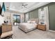 Spacious bedroom with tray ceilings, a king-size bed, and access to the outdoor patio area at 4813 Sparkling Sea Ln, Lakewood Ranch, FL 34211