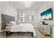 Cozy bedroom with neutral decor, a gray headboard, a mirrored dresser, and ample natural light at 4813 Sparkling Sea Ln, Lakewood Ranch, FL 34211