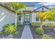 Inviting entryway with brick walkway leads to double doors with decorative wreath accents and tropical landscaping at 4813 Sparkling Sea Ln, Lakewood Ranch, FL 34211