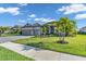 Single-story home featuring a two-car garage, manicured lawn, and tropical landscaping for curb appeal at 4813 Sparkling Sea Ln, Lakewood Ranch, FL 34211