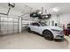 A well-lit garage with a white vehicle parked inside with black wheels at 4813 Sparkling Sea Ln, Lakewood Ranch, FL 34211