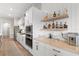 Kitchen featuring white cabinets, stainless steel appliances, and a bar area with open shelving for liquor bottles at 4813 Sparkling Sea Ln, Lakewood Ranch, FL 34211