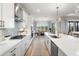 Modern kitchen featuring white cabinets, stainless steel appliances, a large island, and a dining area beyond at 4813 Sparkling Sea Ln, Lakewood Ranch, FL 34211
