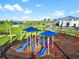 Well-equipped playground with slides and a swing set under a clear sky, backing to homes and lush greenery at 4813 Sparkling Sea Ln, Lakewood Ranch, FL 34211