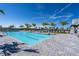 A beautiful swimming pool with lounge chairs and palm trees under a bright blue sky at 4813 Sparkling Sea Ln, Lakewood Ranch, FL 34211