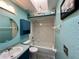 Bathroom with a unique design featuring blue walls, a round mirror, and a tub at 503 Philodendron, Punta Gorda, FL 33955