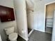 Bathroom featuring a tiled shower, dark wood cabinet, and a toilet with gray floors at 503 Philodendron, Punta Gorda, FL 33955
