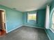 A sunny bedroom is painted a cool color with a window view and matching carpet at 503 Philodendron, Punta Gorda, FL 33955
