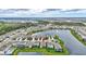 An aerial view shows a lakeside home with a well-maintained lawn in a scenic community at 5313 Halewood Ct, Bradenton, FL 34211