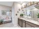 Charming bathroom features dual sinks with granite countertops, decorative mirrors, and a cozy bench for a spa-like experience at 5313 Halewood Ct, Bradenton, FL 34211