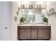 Stylish bathroom showcases dual sinks, granite countertops, and elegant decor, highlighted by decorative mirrors and ample storage at 5313 Halewood Ct, Bradenton, FL 34211