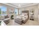 Bedroom featuring a tray ceiling, tufted headboard, and bench with a water view from the window at 5313 Halewood Ct, Bradenton, FL 34211