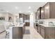 Bright kitchen featuring gray cabinets, granite counters and an island with bar stool seating at 5313 Halewood Ct, Bradenton, FL 34211