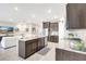 Modern kitchen with a central island, stainless steel appliances, and an open floor plan flowing into the living area at 5313 Halewood Ct, Bradenton, FL 34211