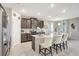 Open-concept kitchen with stainless steel appliances, granite countertops, a large island, and breakfast bar seating at 5313 Halewood Ct, Bradenton, FL 34211