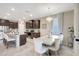 Open concept kitchen and dining area with dark cabinets, stainless steel appliances, island, and chandelier at 5313 Halewood Ct, Bradenton, FL 34211