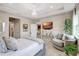 Relaxing bedroom boasts a comfortable seating area with a swivel chair, a large TV, and stylish decor, perfect for unwinding at 5313 Halewood Ct, Bradenton, FL 34211