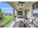 Relaxing outdoor patio area with modern wicker furniture and a view of the backyard and lake at 5313 Halewood Ct, Bradenton, FL 34211