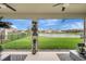 Covered patio view featuring serene backyard lake and well-maintained landscaping with upscale patio furniture at 5313 Halewood Ct, Bradenton, FL 34211