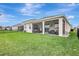 Rear exterior shows covered patio, well-manicured lawn and backyard fencing at 5313 Halewood Ct, Bradenton, FL 34211