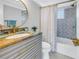 Stylish bathroom features a vanity with a stone countertop, brushed gold fixtures, and a shower-tub combination at 5892 17Th W St # C25, Bradenton, FL 34207