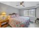 Bright bedroom featuring a queen bed with flamingo-themed bedding, ceiling fan, and natural light from a large window at 5892 17Th W St # C25, Bradenton, FL 34207