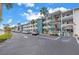 Three-story condominium building featuring covered walkways, a parking area, and lush landscaping at 5892 17Th W St # C25, Bradenton, FL 34207