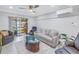 Bright living room with comfortable seating, a modern ceiling fan, and access to the enclosed patio at 5892 17Th W St # C25, Bradenton, FL 34207