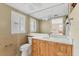 Bright bathroom with a large mirror, vanity, and toilet, awaiting renovation to elevate its appeal at 6140 Midnight Pass Rd # A10, Sarasota, FL 34242