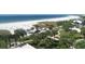 Scenic aerial view of the beach with white sand, clear water, and palm-lined grounds at 6140 Midnight Pass Rd # A10, Sarasota, FL 34242