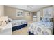 Bright bedroom featuring two twin beds with matching blue and white seashell patterned bedding and white wood furnishings at 6140 Midnight Pass Rd # A10, Sarasota, FL 34242