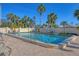 Relaxing community pool area featuring clear blue water, lounge chairs and plenty of palm trees at 6140 Midnight Pass Rd # A10, Sarasota, FL 34242