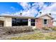 Single-story home with a tan exterior, red brick accent wall, and green shutters underneath a cloudy blue sky at 6140 Midnight Pass Rd # A10, Sarasota, FL 34242