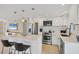 Open kitchen boasts stainless steel appliances, white cabinetry, and a quartz island with seating for two at 6140 Midnight Pass Rd # A10, Sarasota, FL 34242