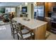 Island kitchen featuring counter seating, stainless appliances, custom cabinetry, and seamless access to the living area at 6140 Midnight Pass Rd # A10, Sarasota, FL 34242