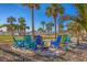 Relaxing outdoor seating area with colorful Adirondack chairs, palm trees, and a glimpse of the beach at 6140 Midnight Pass Rd # A10, Sarasota, FL 34242