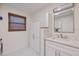 A bathroom featuring a vanity with storage, a window with blinds, and tiled floors at 645 Palmetto Dr, Venice, FL 34293