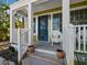 Inviting covered porch with white railing, wicker chair, and view of the lush tropical surroundings at 7119 Longboat E Dr, Longboat Key, FL 34228