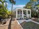 Charming home exterior with a welcoming white-railed front porch and tropical landscaping at 7119 Longboat E Dr, Longboat Key, FL 34228